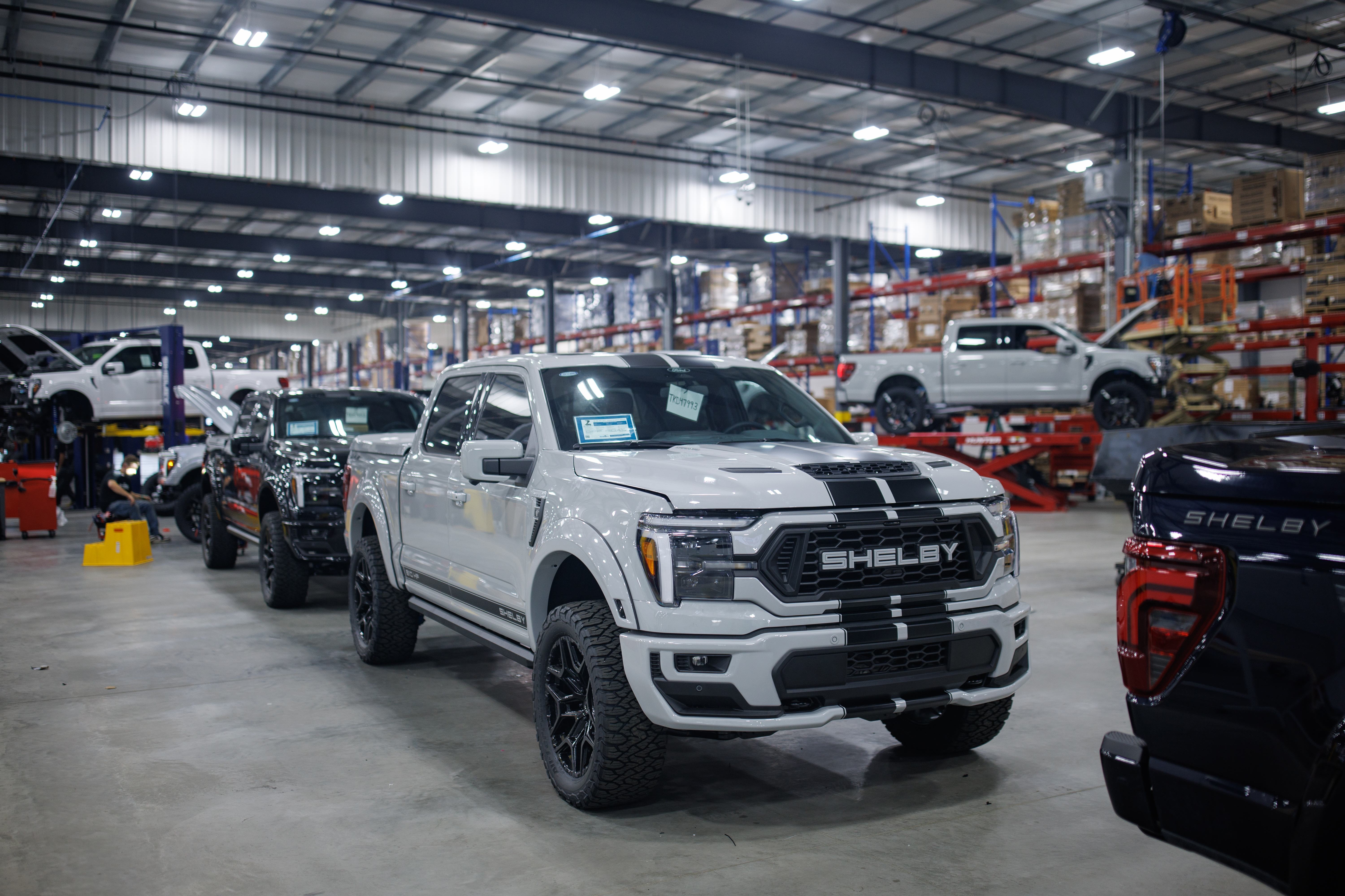 Several completed Shelby trucks inside a Shelby Performance facility